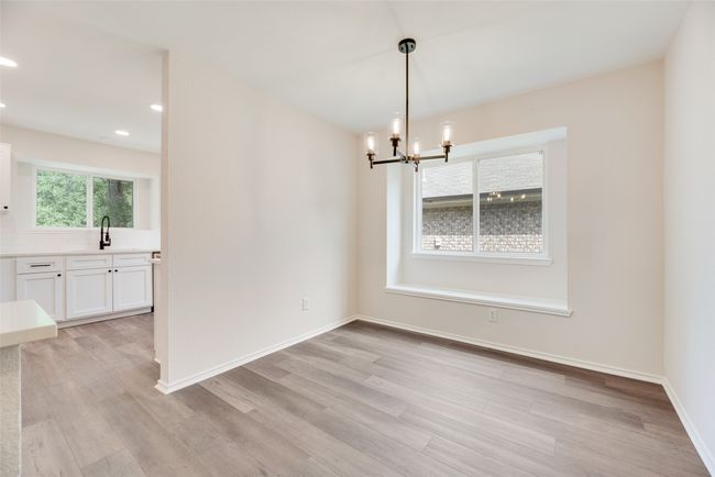 Unfurnished dining area featuring light wood finished floors, a chandelier, recessed lighting, a sink, and baseboards | Image 7