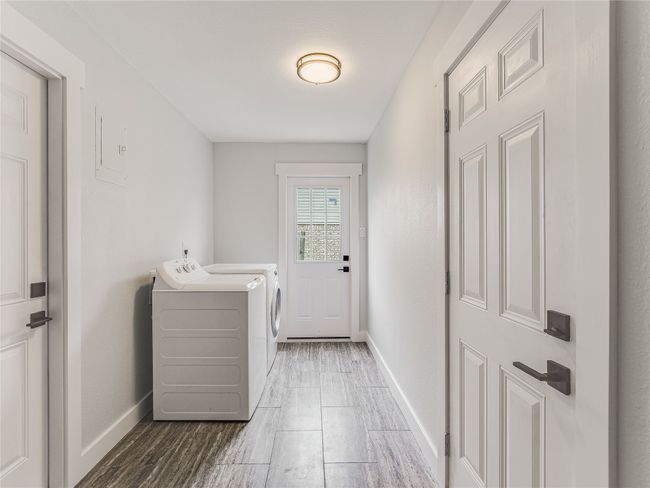 Clothes washing area featuring laundry area, wood finished floors, baseboards, and washer and dryer | Image 9