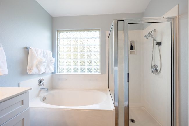 Full bathroom featuring a garden tub, a stall shower, and vanity | Image 15