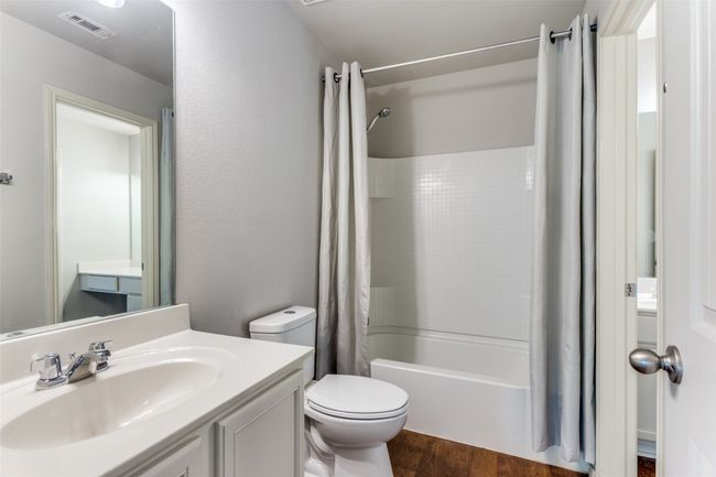 Full bath with wood finished floors, vanity, and shower / bath combination with curtain | Image 35