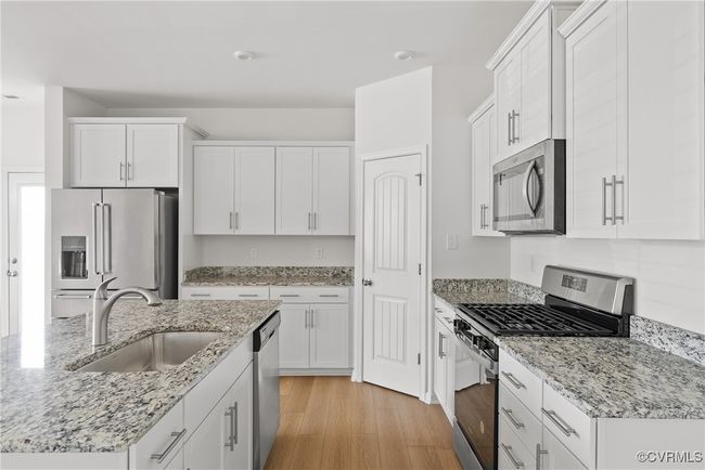Kitchen with white cabinetry, appliances with stainless steel finishes, and a sink | Image 12