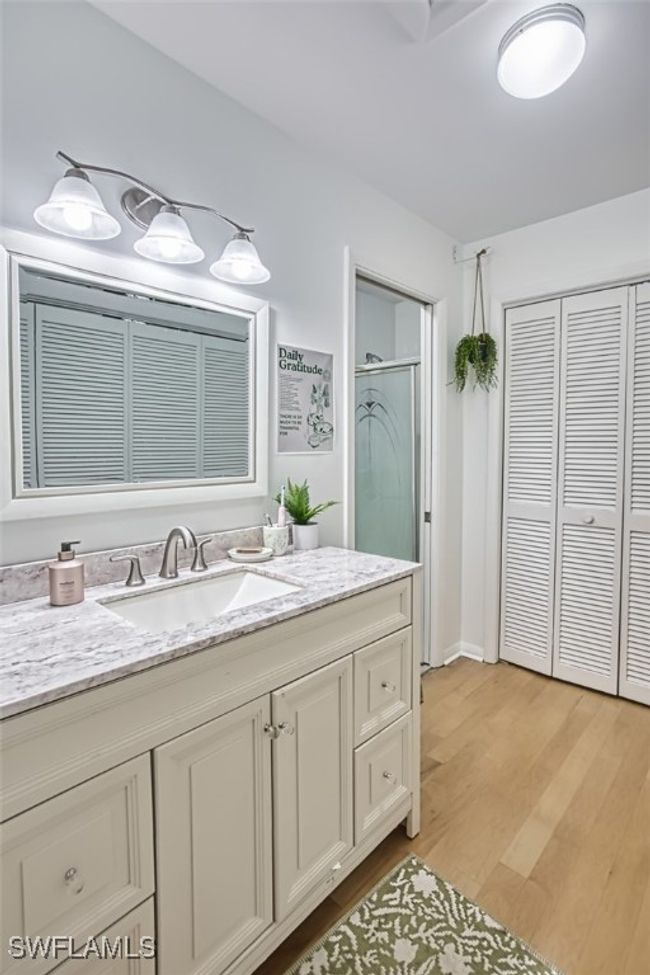 Bathroom with a closet, wood finished floors, a shower stall, and vanity | Image 22