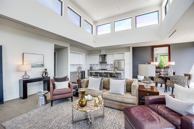 Living area featuring baseboards, a high ceiling, and light wood-style floors | Image 8