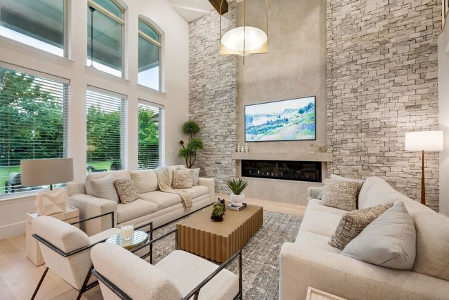 Living room featuring wood finished floors, a towering ceiling, and a glass covered fireplace | Image 5