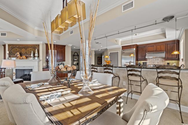 Dining area featuring a tray ceiling, ornamental molding, a fireplace, and recessed lighting | Image 16