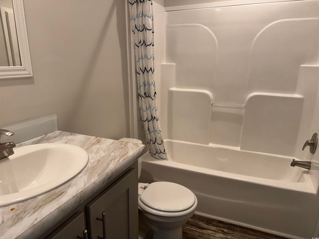 Full bath featuring vanity, shower / tub combo with curtain, and wood finished floors | Image 28