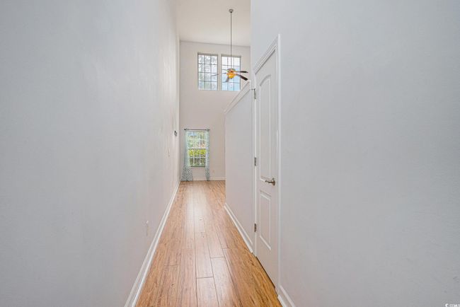 Hallway with light wood-style floors and a high ceiling | Image 6