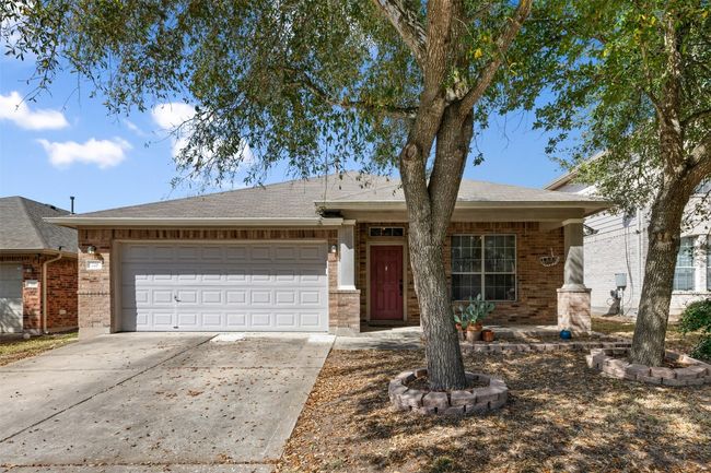 Ranch-style house with brick siding, concrete driveway, an attached garage, and a shingled roof | Image 4