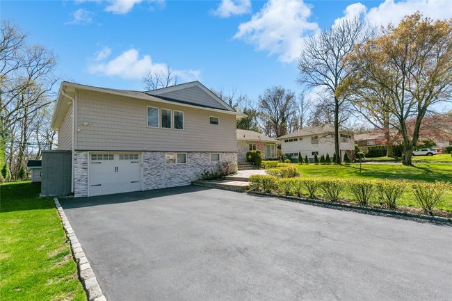 View of home's exterior with a lawn, driveway, an attached garage, and stone siding | Image 29