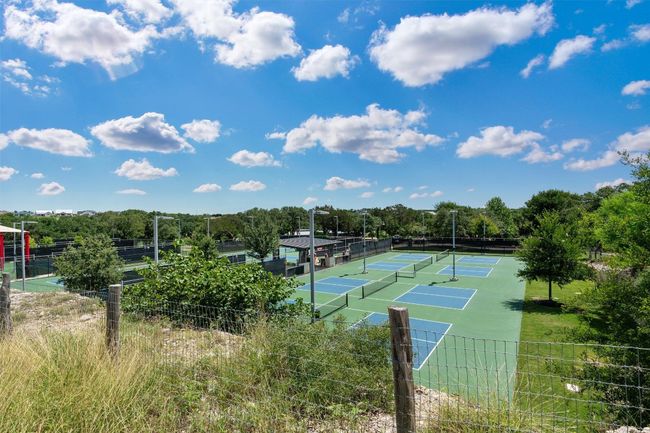 View of pickleball courts featuring fencing and a central pavillion. | Image 35