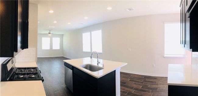 Kitchen featuring gas range oven, dishwasher, light countertops, dark wood-type flooring, and recessed lighting | Image 6