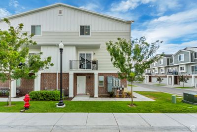 Multi unit property with a garage, a balcony, central air condition unit, and a front lawn | Image 3