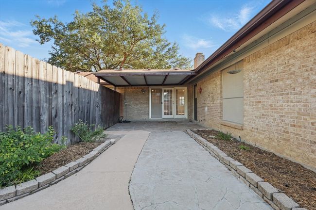 View of exterior entry with a chimney, brick siding, fence, and french doors | Image 32
