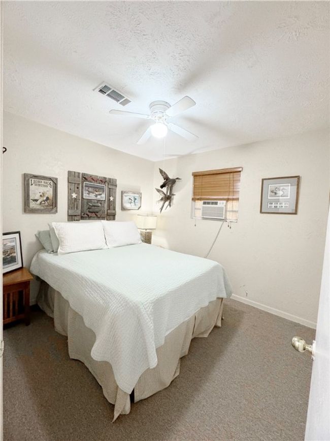 Carpeted bedroom with visible vents, baseboards, ceiling fan, a textured ceiling, and cooling unit | Image 13