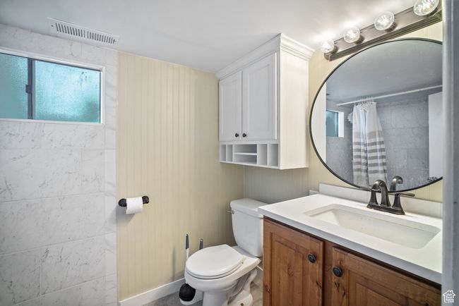 Bathroom featuring vanity, toilet, and tiled shower | Image 22