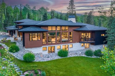 Back house at dusk with a balcony and a yard | Image 1