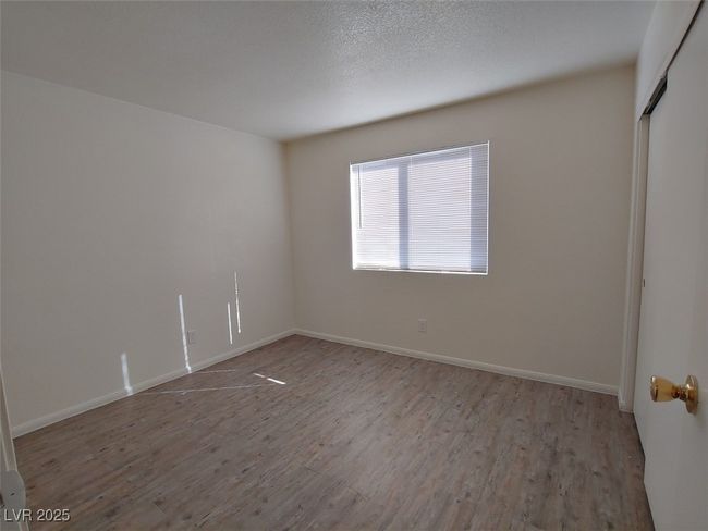 Unfurnished room with light wood-type flooring and a textured ceiling | Image 9