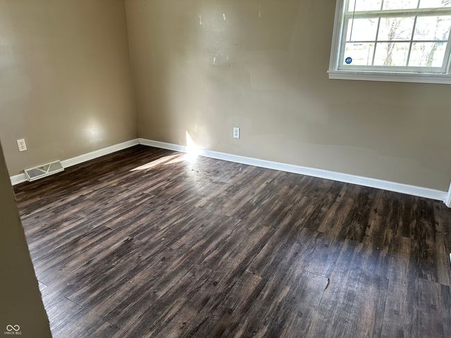spare room featuring baseboards and dark wood-type flooring | Image 7