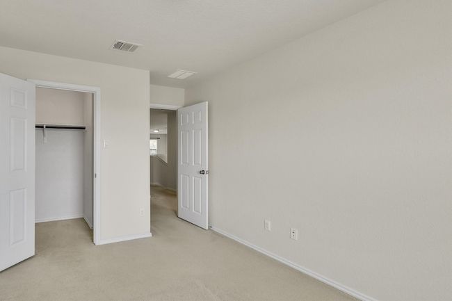 Unfurnished bedroom featuring a spacious closet, visible vents, a closet, baseboards, and light colored carpet | Image 20
