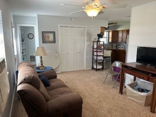 Living area with light colored carpet and a ceiling fan | Image 22