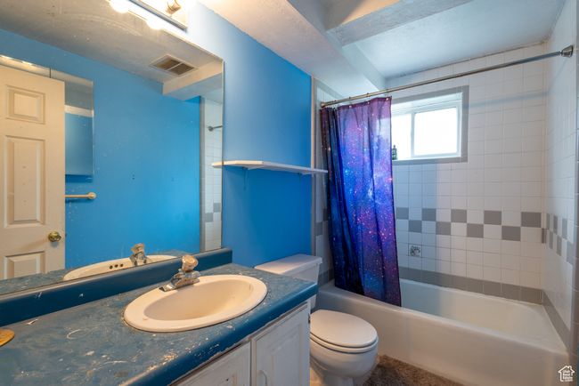 Full bathroom featuring visible vents, toilet, shower / tub combo with curtain, and vanity | Image 24