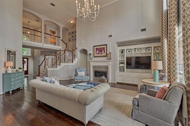Staircase adds to the beauty of this room. One secondary bedroom located at the top of the stairs has ensuite bathroom. Two additional bedrooms are down the hall to the left. | Image 11