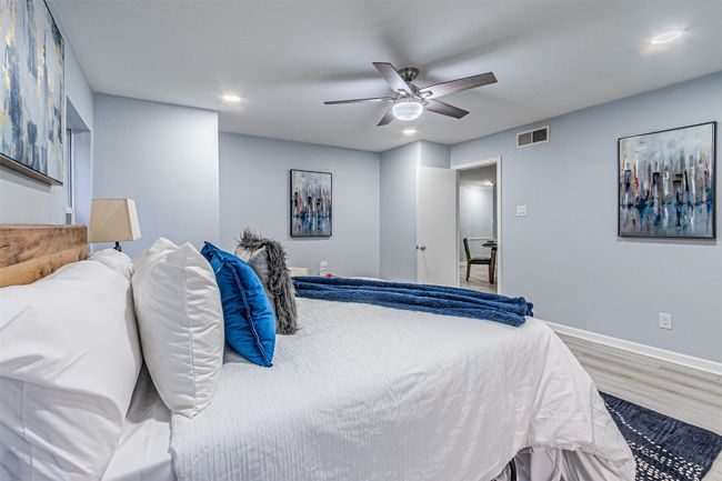 Bedroom with a ceiling fan, visible vents, wood finished floors, baseboards, and recessed lighting | Image 10