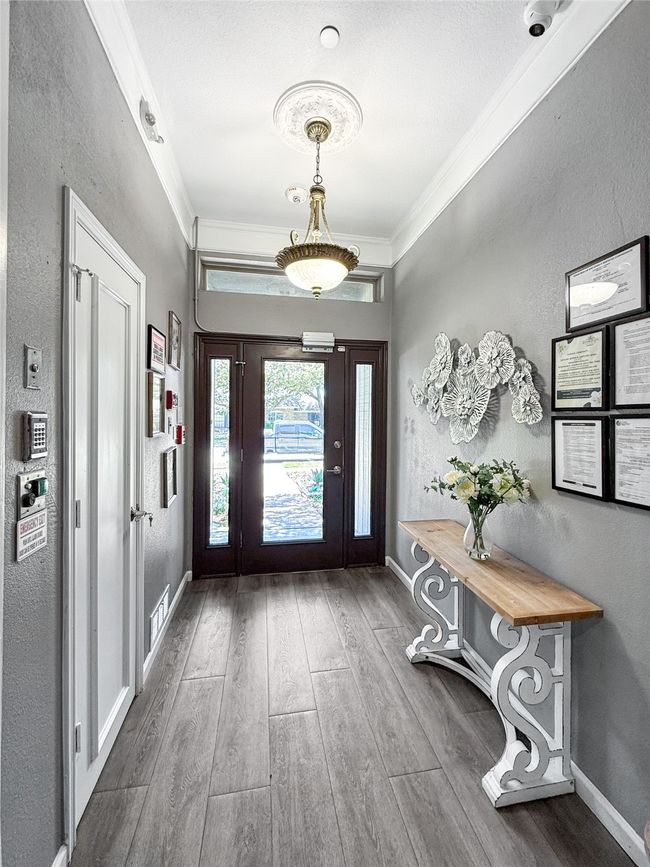 Entrance foyer featuring a textured wall, crown molding, and wood finished floors | Image 4