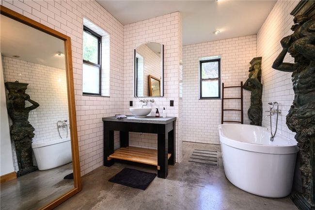 Bathroom with tile walls, plenty of natural light, concrete flooring, and vanity | Image 12