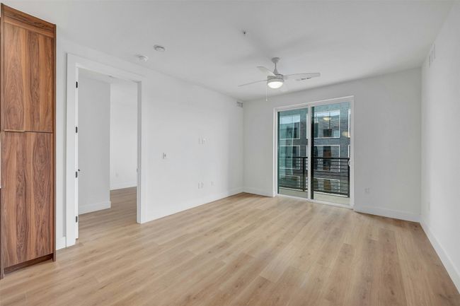 Spare room featuring a ceiling fan and light wood-style floors | Image 7