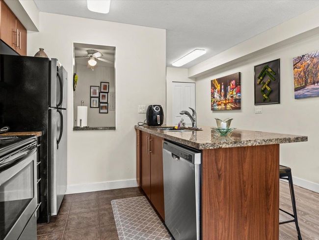 Kitchen with appliances with stainless steel finishes, a peninsula, a kitchen breakfast bar, brown cabinets | Image 9