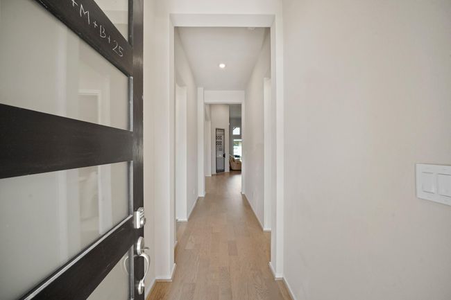 The elongated foyer welcomes you into the home with beautiful flooring, high ceilings, and recessed lighting. | Image 4