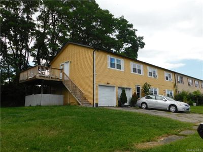 View of front of property with a garage, a deck, and a front lawn | Image 2