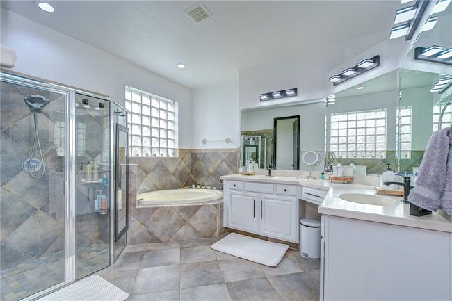 En-suite bathroom features two sinks, jetted tub, and walk-in shower! | Image 17