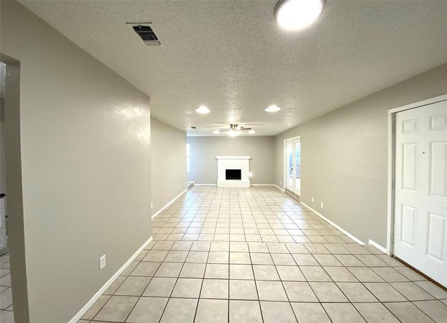 8836 Unfurnished living room featuring a textured ceiling, ceiling fan, and light tile flooring | Image 11