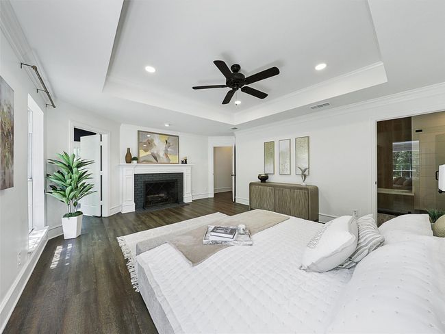 Bedroom with a fireplace, a tray ceiling, dark wood-type flooring, and recessed lighting | Image 12