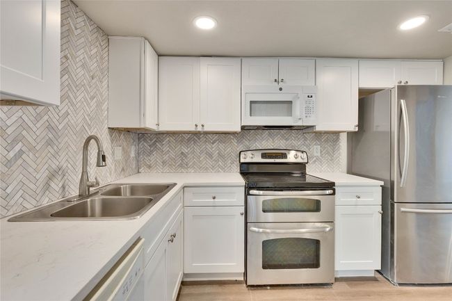 Updated kitchen with quartz counter tops, tile backsplash and stainless appliances. | Image 9