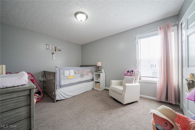 Bedroom with a textured ceiling and light colored carpet | Image 17