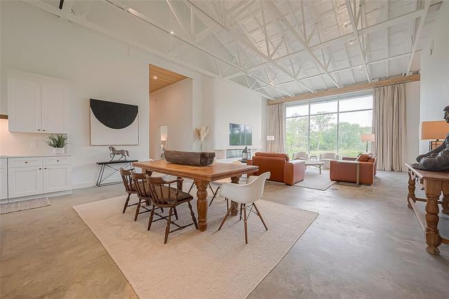 View of kitchen, breakfast room and living room. Notice the built-in TV/fireplace and expansive back window. | Image 5