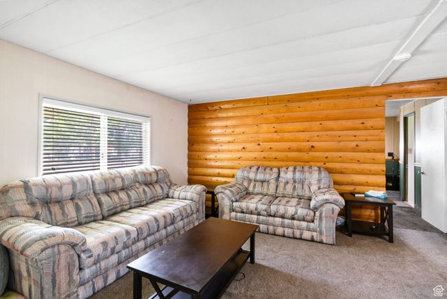 Living room with rustic walls and carpet | Image 10