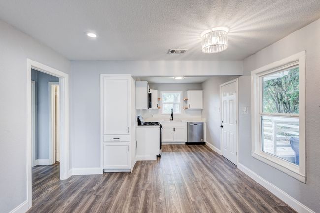 Kitchen with gas stove, dishwasher, a sink, dark wood-type flooring, and white cabinetry | Image 15