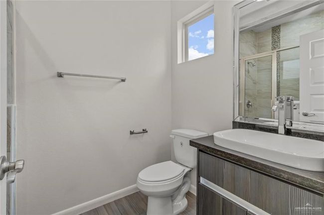 Full bath with a shower stall, vanity, and wood finished floors | Image 8