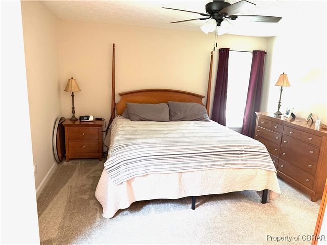 Primary Bedroom with carpet flooring, ceiling fan, and baseboards, primary bath with large walk-in shower and built in seat. | Image 8