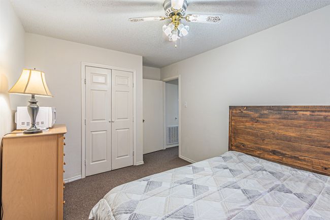 Bedroom with carpet floors, a textured ceiling, a closet, and ceiling fan | Image 26