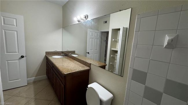 Bathroom with toilet, tile patterned flooring, visible vents, and vanity | Image 5