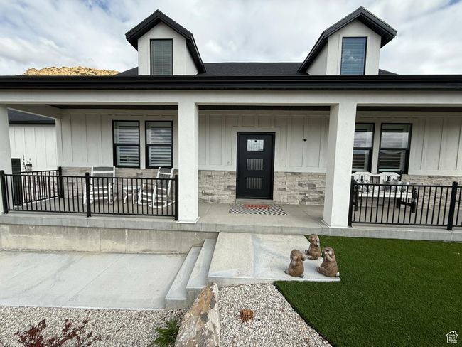 Entrance to property with covered porch, stone siding, board and batten siding, and a lawn | Image 4
