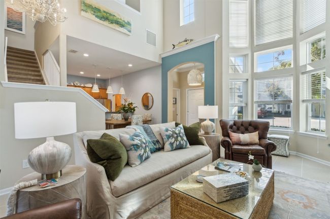 Open-concept living area featuring vaulted ceilings and oversized bay windows. | Image 5