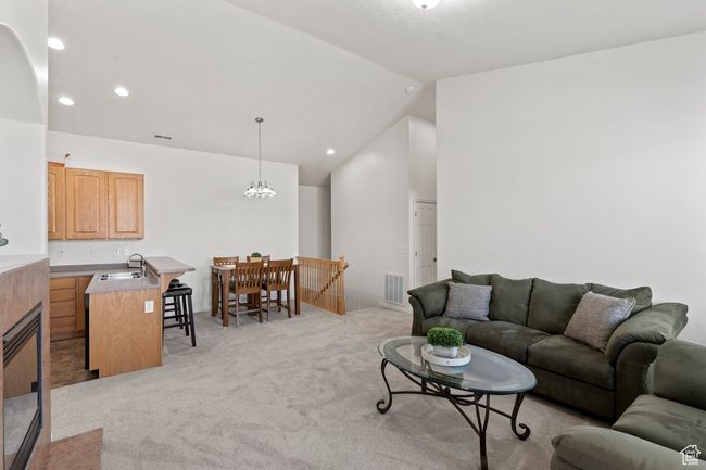 Living room with visible vents, recessed lighting, light colored carpet, and vaulted ceiling | Image 5