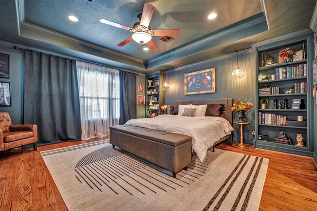 Spacious primary bedroom features moody tones that create a cozy and inviting atmosphere, includes the original hardwood floors that add warmth and character. (Please Note: Seller happy to accommodate buyer's if neutral or lighter paint desired for primary suite) | Image 26
