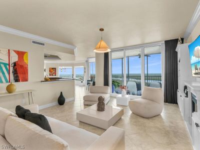 Tiled living room featuring a water view and ornamental molding | Image 3